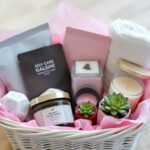 A beautifully arranged self-care gift basket with bath bombs, face masks, candles, and a soft towel
