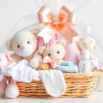 Beautifully arranged baby shower gift basket with soft toys, clothes and care products