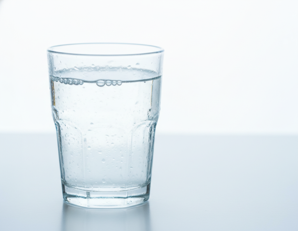 glass of water representing hydration for saliva production